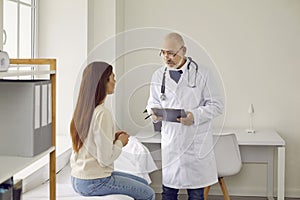 Senior male doctor consult woman patient in hospital