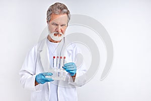 Senior male doctor examining, studying the coronavirus tests in tube