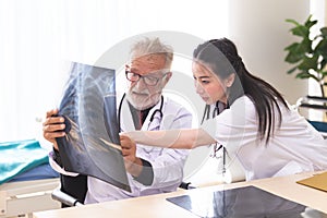 Senior male doctor is giving women doctor visiting radiologist for x-ray exam