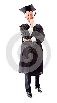 Senior male graduate standing with finger in mouth