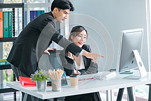 Senior male officer helping female worker with her computer works, for teamwork concept