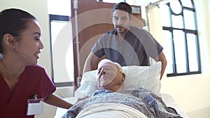 Senior Male Patient Being Wheeled Along Hospital Corridor