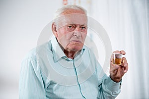 Senior male patient holding urin sample photo