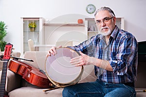 Senior male repairman repairing musical instruments at home