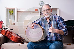 Senior male repairman repairing musical instruments at home