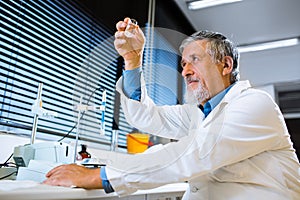 Senior male researcher carrying out scientific research in a lab