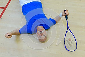 senior male tennis player resting on floor