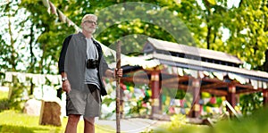 Senior male traveler near Asian temple. Adventure is ageless