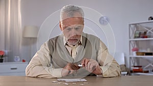 Senior male trying to collect puzzle, memory problems, cognitive impairment