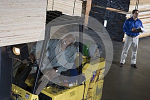 Senior Male Worker Stacking Wooden Planks