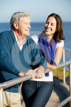 Senior Man With Adult Daughter Looking At Sea