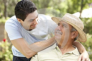 Senior Man With Adult Son In Garden