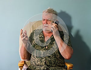 Senior man annoyed on mobile cell phone.