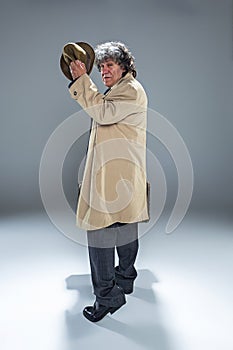 The senior man as detective or boss of mafia on gray studio background