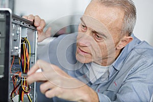 senior man assembling desktop computer photo