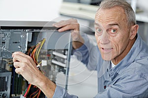 senior man assembling desktop computer