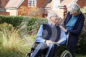 Senior Man Being Pushed In Wheelchair By Wife photo
