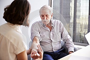 Senior Man Being Vaccinated With Flu Jab By Female Doctor In Hospital Office photo