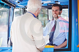 Senior Man Boarding Bus And Buying Ticket