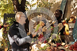 Senior man buying fresh organic vegetables at farmers market