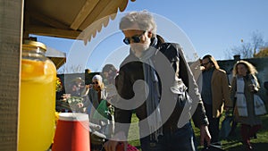 Senior man buys products at farmers market