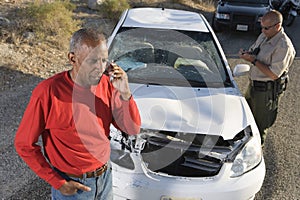 Senior Man On Call With Traffic Cop Writing Ticket