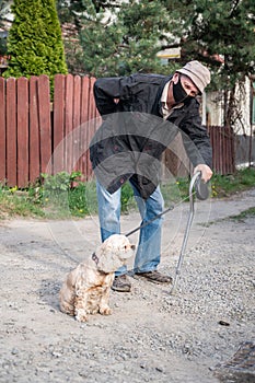Senior man with a cane walking with a dog