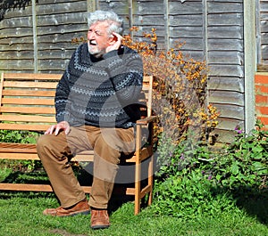 Senior man cannot hear, hand raised to ears. photo