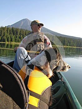 Senior Man canoeing with Dog