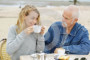 senior man and carer having coffee break