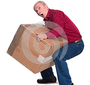 Senior man carries a heavy box