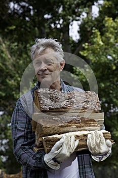 Senior man carrying firewood