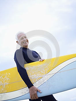 Senior Man Carrying Surfboard