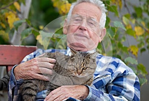 Senior man with cat in courtyard
