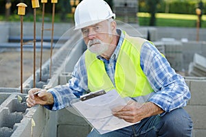 senior man checking cement blocks photo