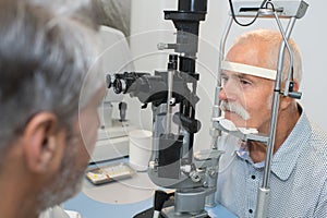 Senior man checking vision with ophtalmologist