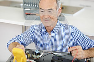 Senior man checking voltage