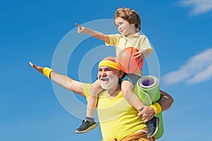 Senior man and child in family health club. Doing sports is free. Grandpa and grandson spotting. Grandfather and child