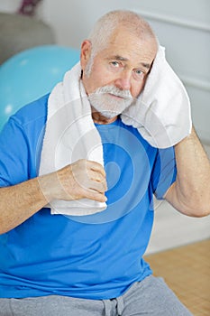 senior man cleaning head with towel