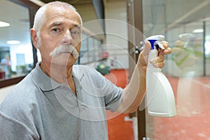 senior man cleaning window glass