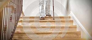 Senior man climbing downstairs with walking stick