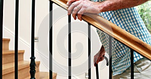 Senior man climbing upstairs with walking stick