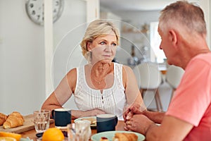 Senior Man Comforting Woman Suffering With Depression At Breakfast Table At Home