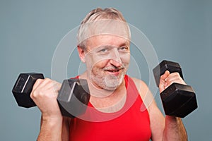 Senior man with a comical approach to fitness This studio shot Holding dumbbells