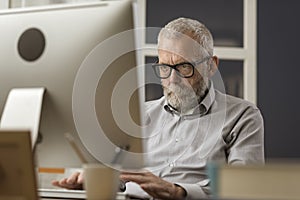 Senior man connecting with his computer at home