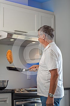 Senior man cooking in modern kitchen