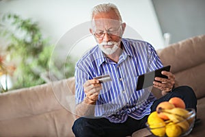 Senior man with credit card for online banking