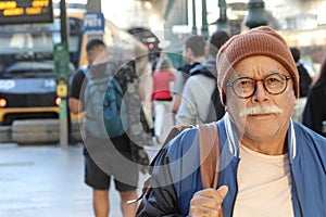 Senior man in crowded train station