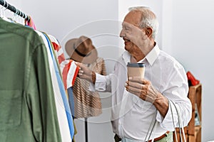 Senior man customer choose clothes drinking coffee at clothing store