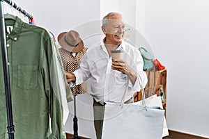 Senior man customer choose clothes drinking coffee at clothing store